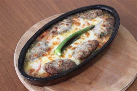 Güveç içerisinde kaşar peyniriyle servis edilen köfte
