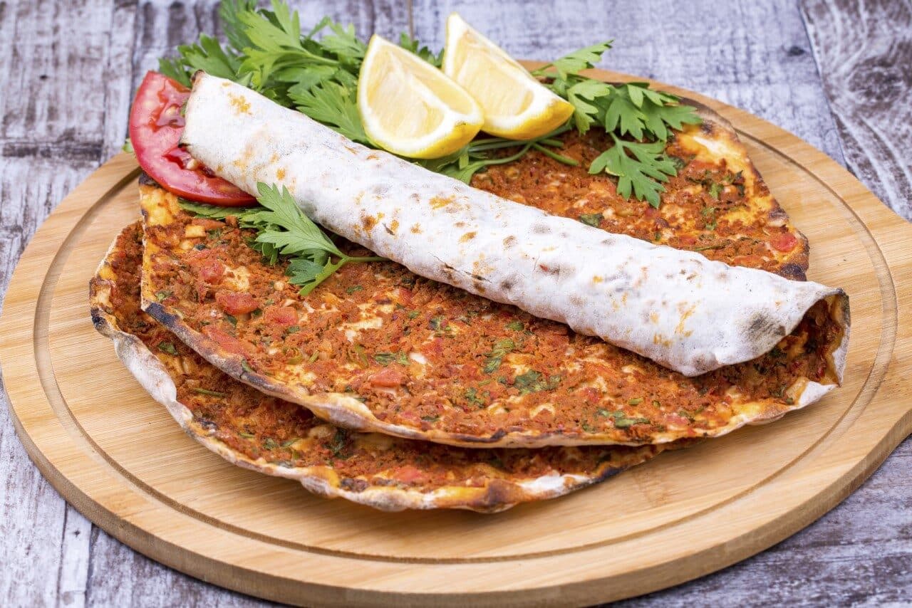 Maydanoz ve limon eşliğinde servis edilen lahmacun